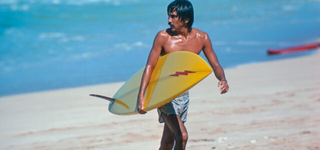 Gerry Lopez mit Surfboard am Strand